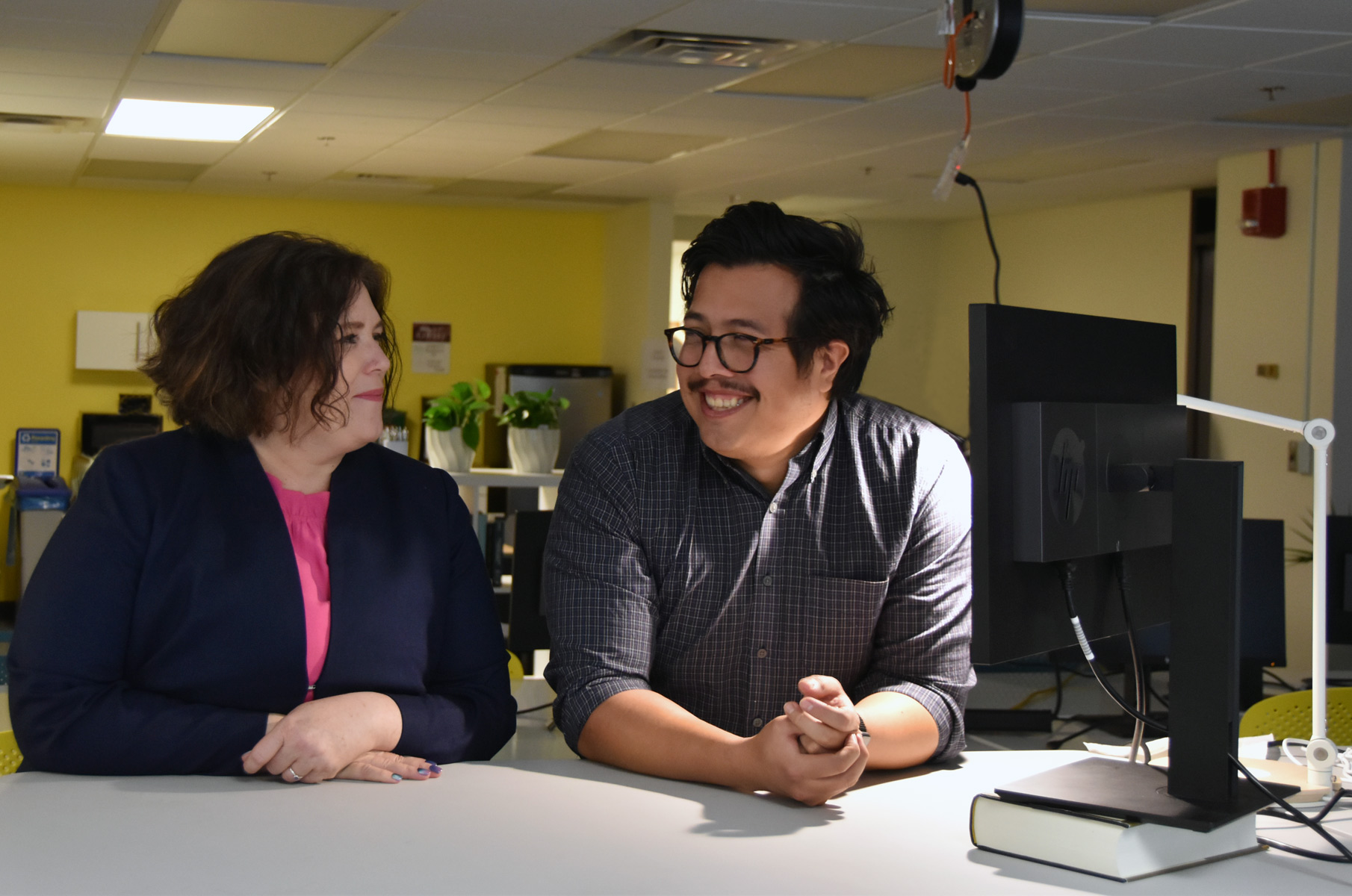 CID Graduate Student Fellow Giovanni Roman Torres and Student Fellow Shauna Dyer sit at a work station in the Stone Center for Inequality Dynamics