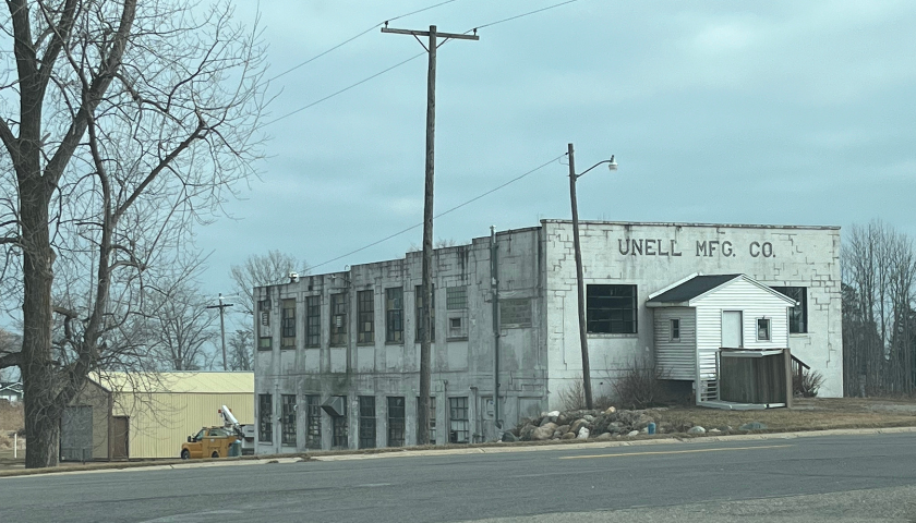 A street view picture of an  old factory building in rural Michigan
