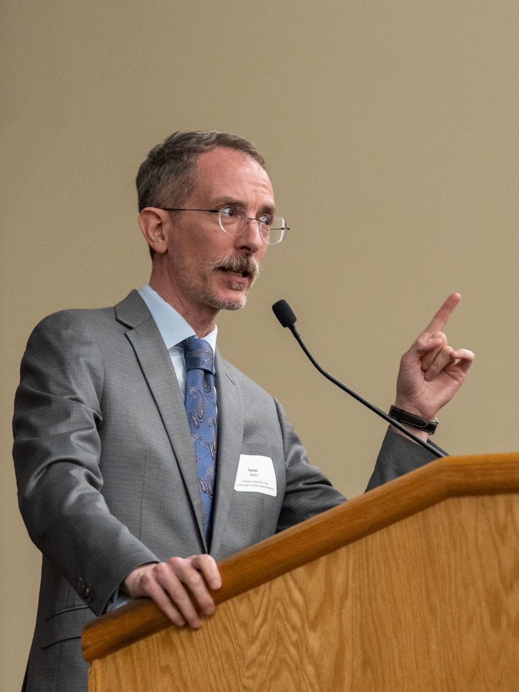 Isaac Martin stands presenting at a podium.